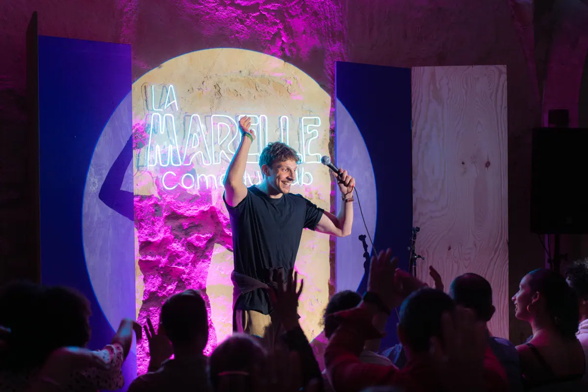 Humoriste micro en main face au public — La Marelle Bleue, soirée stand-up du vendredi au Pas de Lune, Bordeaux