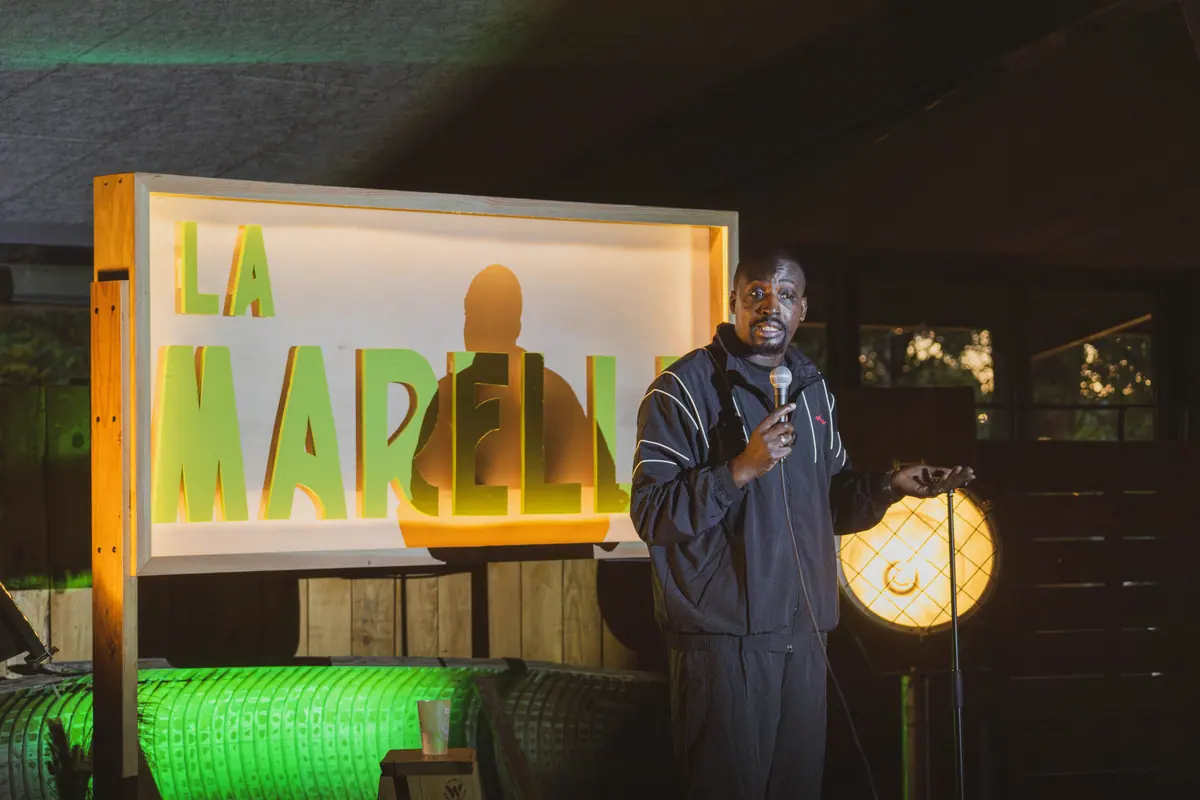 Humoriste sur scène à La Marelle Verte — comedy club en plein air aux Chantiers de la Garonne, Bordeaux